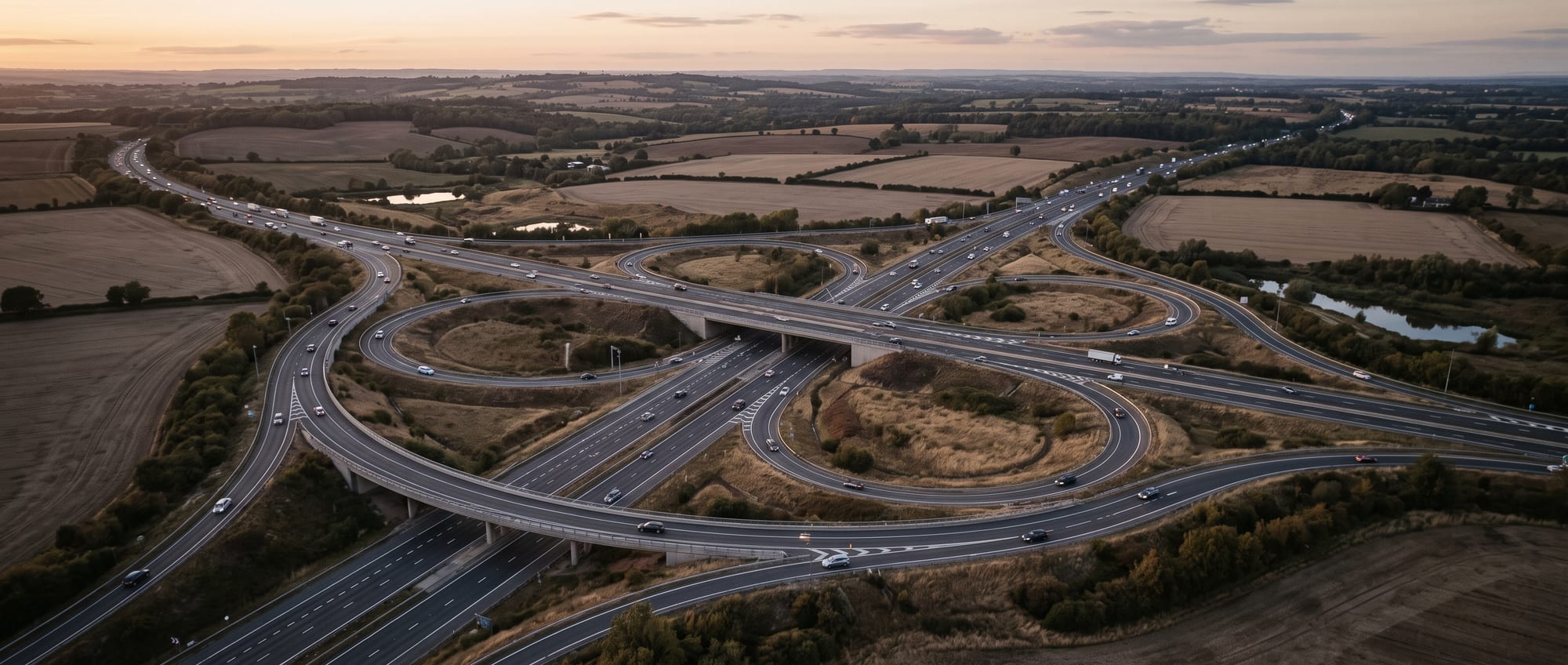 Aerial view of an orderly motorway interchange with flowing traffic at dusk